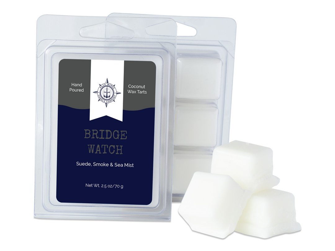 Single Bridge Watch wax melt clamshell on a white background. This military inspired coconut wax wax melt is 2.5 ounces and has 6 sections. The color of the candle label is Navy blue with a dark gray wave header and a white flag featuring the Fair Winds Candle logo on the top center.